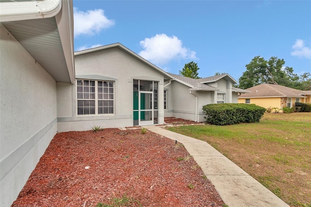 view of front of house featuring stucco siding and a front lawn