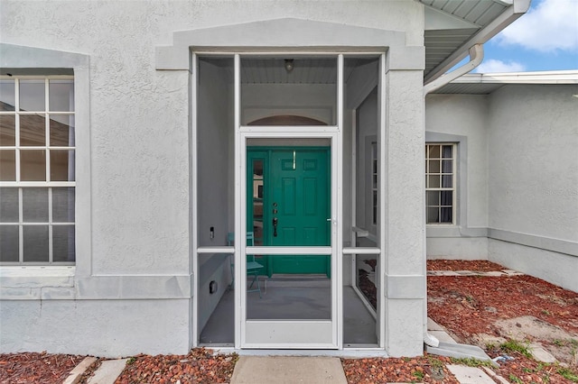 entrance to property featuring stucco siding
