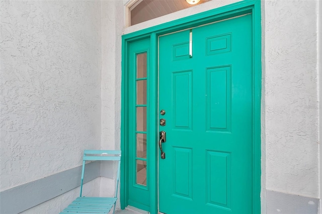 doorway to property featuring stucco siding