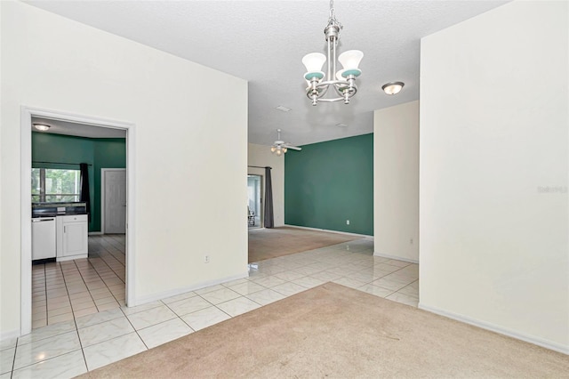 empty room featuring light colored carpet, light tile patterned flooring, a chandelier, baseboards, and a ceiling fan