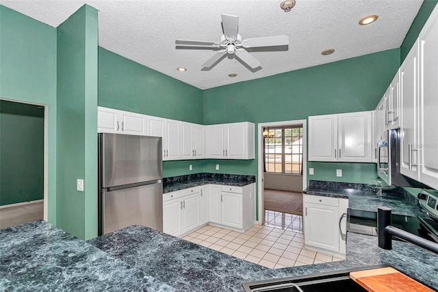 kitchen with stainless steel appliances, white cabinets, a sink, ceiling fan, and a textured ceiling