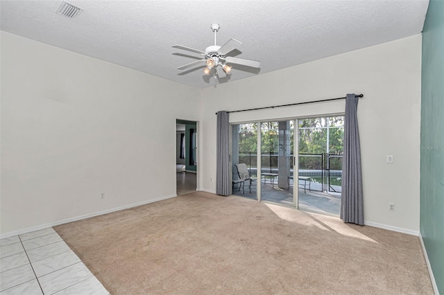 spare room featuring ceiling fan, a textured ceiling, baseboards, and carpet floors