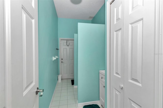 bathroom with tile patterned floors, baseboards, and a textured ceiling
