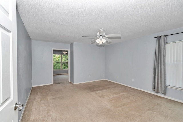 unfurnished room with a ceiling fan, light carpet, baseboards, and a textured ceiling
