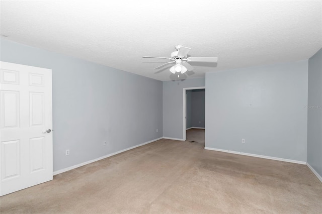 spare room with light carpet, baseboards, ceiling fan, and a textured ceiling