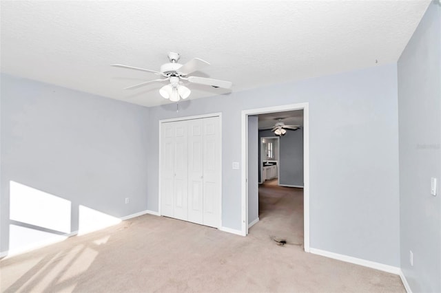 unfurnished bedroom with a closet, carpet flooring, baseboards, a ceiling fan, and a textured ceiling