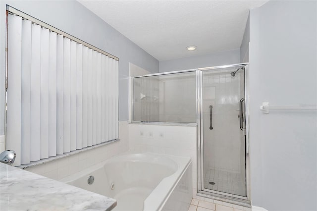 full bathroom with a shower stall, a jetted tub, and a textured ceiling