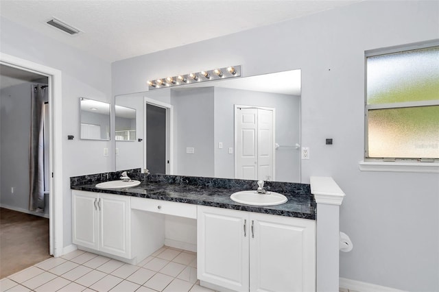 bathroom with tile patterned flooring, double vanity, and baseboards