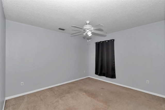 spare room with ceiling fan, carpet floors, baseboards, and a textured ceiling