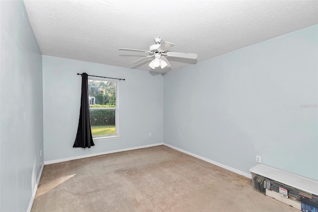 spare room featuring carpet flooring, a ceiling fan, a textured ceiling, and baseboards