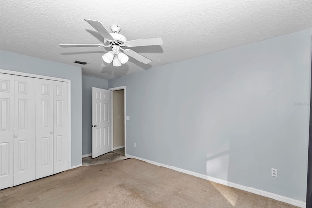 unfurnished bedroom with a closet, carpet flooring, baseboards, a ceiling fan, and a textured ceiling