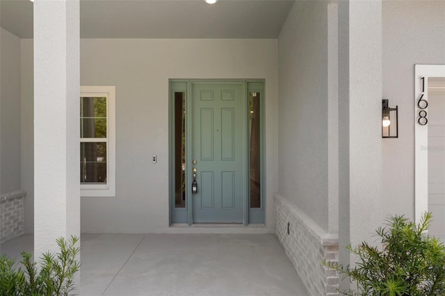 entrance to property featuring stucco siding