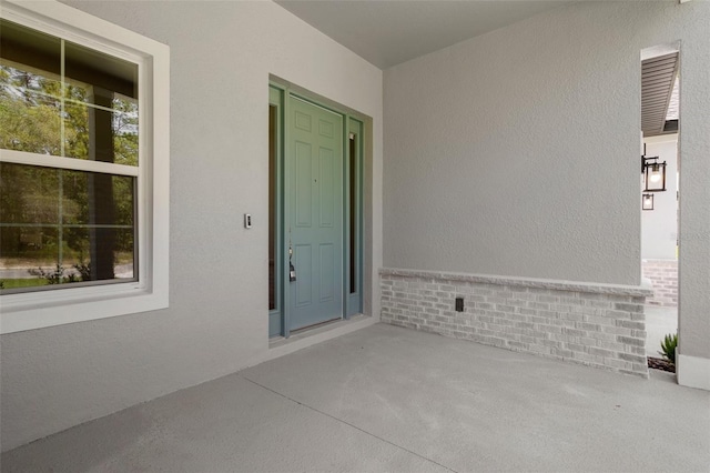 entrance to property with brick siding and stucco siding
