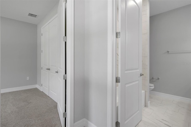 hall with baseboards and visible vents