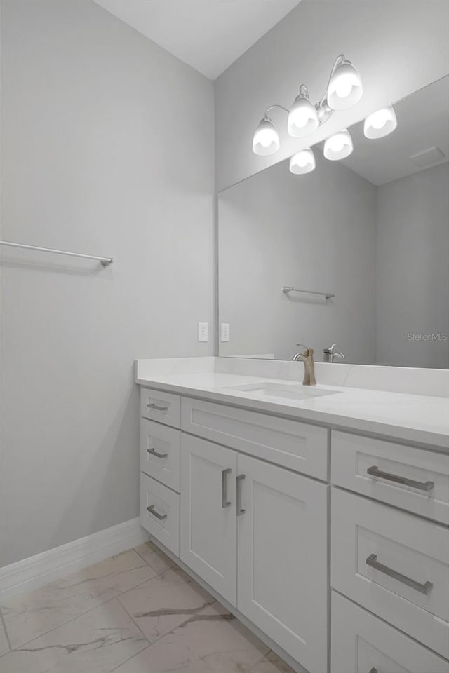 bathroom featuring baseboards, marble finish floor, and vanity