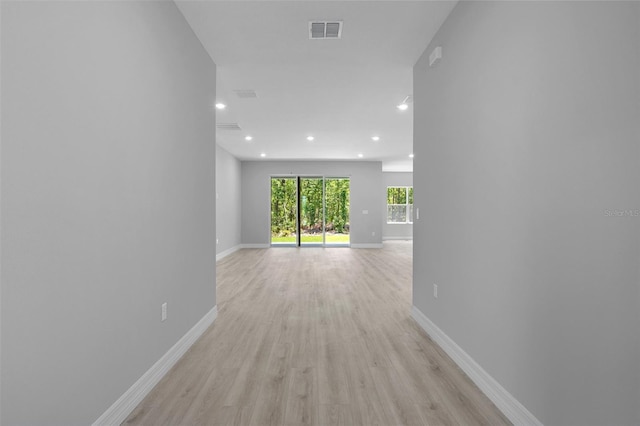 hallway with visible vents, recessed lighting, baseboards, and light wood-type flooring