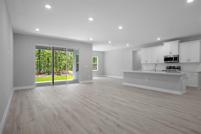 kitchen featuring plenty of natural light, open floor plan, a sink, and appliances with stainless steel finishes
