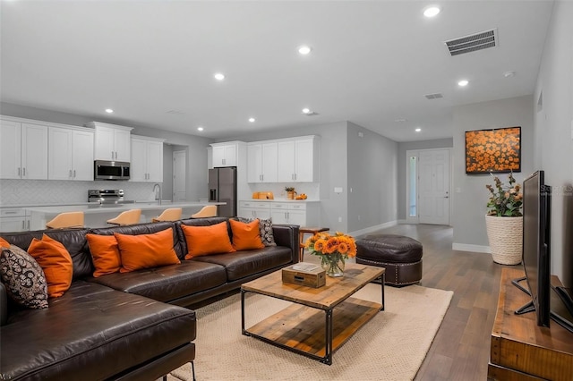 living area featuring recessed lighting, baseboards, visible vents, and wood finished floors
