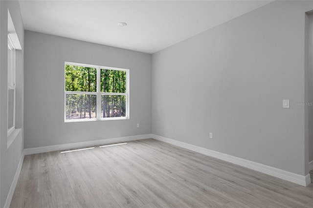 empty room featuring baseboards and light wood-type flooring