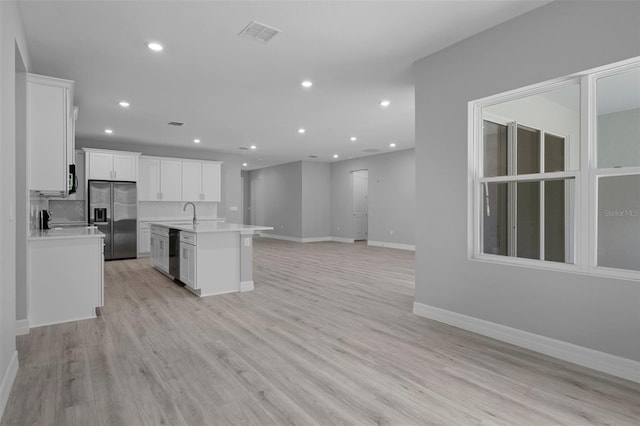kitchen with stainless steel refrigerator with ice dispenser, open floor plan, recessed lighting, and dishwasher