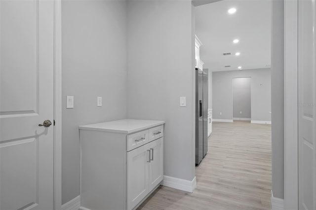 hall featuring a barn door, recessed lighting, baseboards, light wood-type flooring, and visible vents