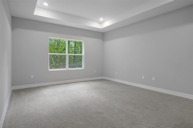 spare room featuring recessed lighting, carpet flooring, baseboards, and a tray ceiling