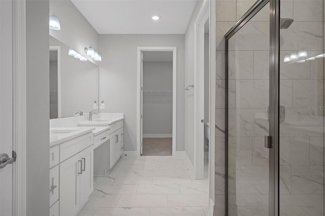 full bath featuring double vanity, a shower stall, a sink, marble finish floor, and a spacious closet