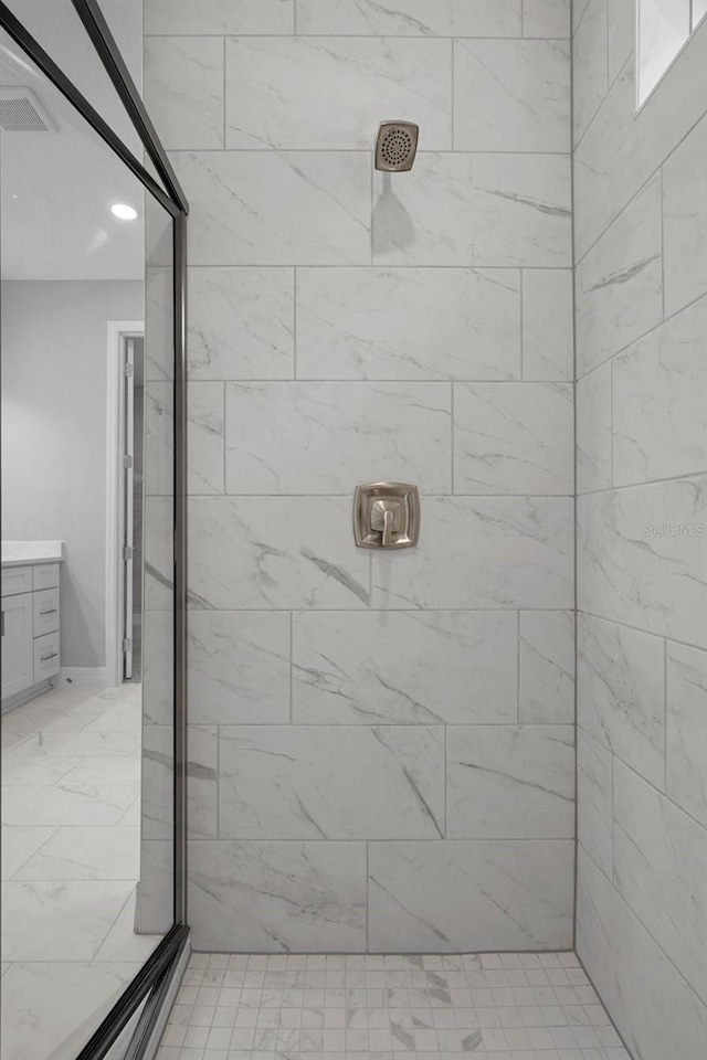 bathroom featuring a tile shower and vanity
