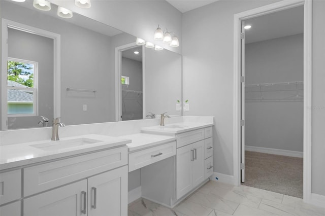 full bath with vanity, marble finish floor, baseboards, and a spacious closet