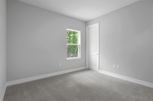 spare room with baseboards and carpet flooring