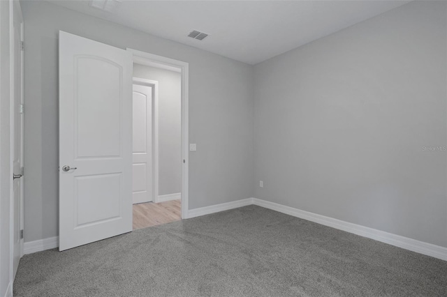 unfurnished room featuring visible vents, carpet flooring, and baseboards