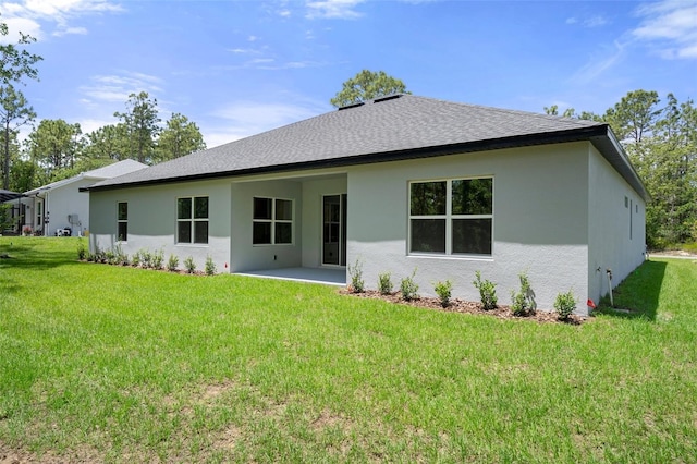 back of house featuring a patio, a shingled roof, stucco siding, and a yard