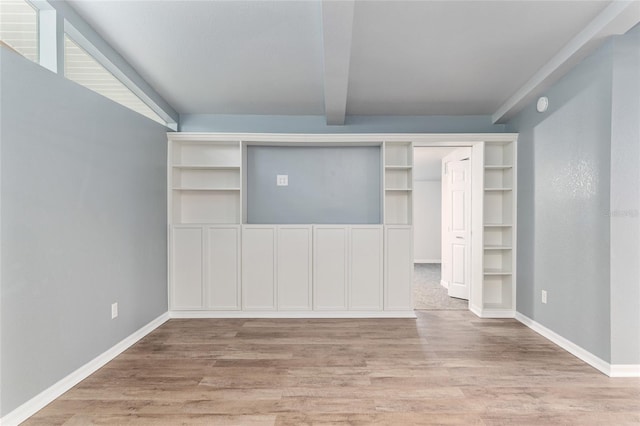 interior space with beamed ceiling, light wood-type flooring, and baseboards