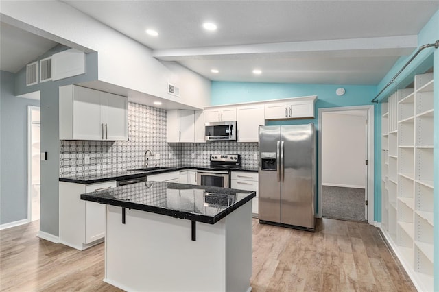 kitchen featuring dark countertops, vaulted ceiling with beams, a sink, decorative backsplash, and appliances with stainless steel finishes