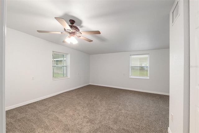 carpeted empty room with ceiling fan, baseboards, a healthy amount of sunlight, and visible vents