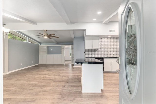 kitchen featuring dark countertops, a sink, fridge, white cabinetry, and visible vents
