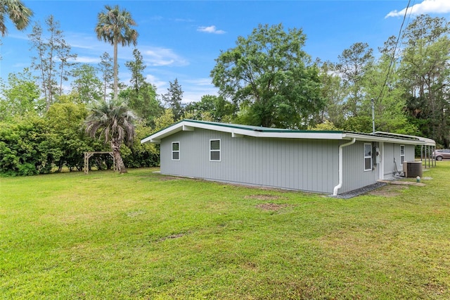 view of property exterior featuring a lawn and central AC