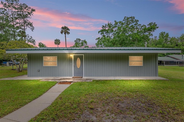 view of front of house with a lawn and metal roof