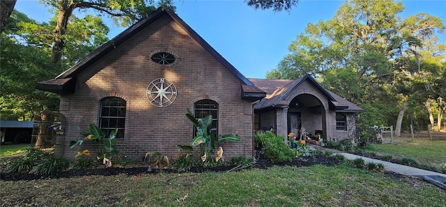 view of front of house featuring brick siding and a front yard