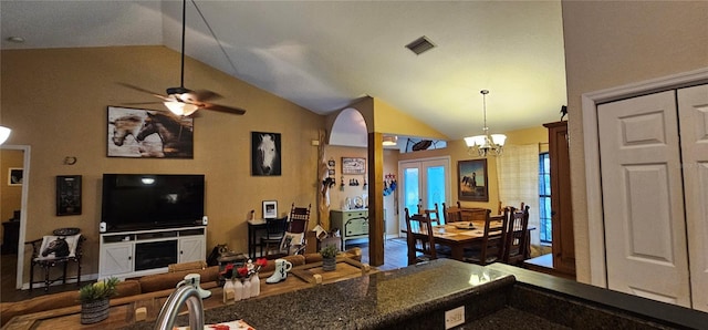 kitchen featuring ceiling fan with notable chandelier, visible vents, pendant lighting, open floor plan, and lofted ceiling