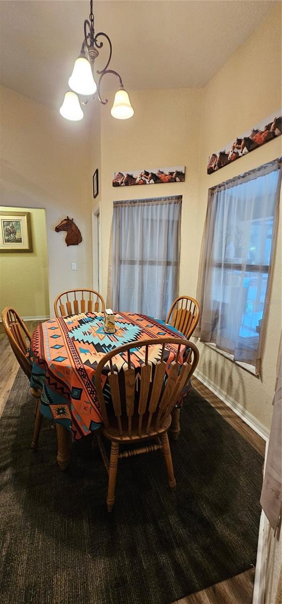 dining area with baseboards and wood finished floors