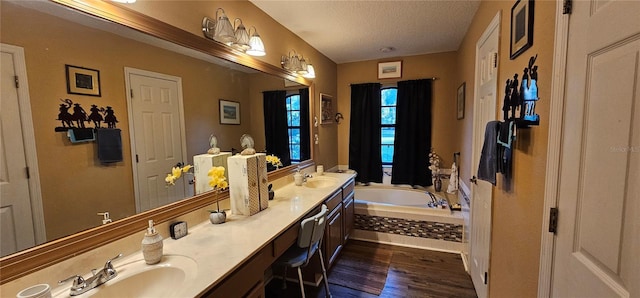 full bathroom with wood finished floors, a garden tub, double vanity, and a sink