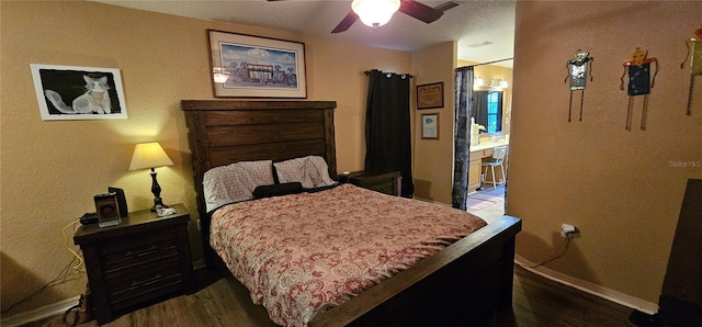 bedroom with wood finished floors, ceiling fan, a textured wall, and baseboards