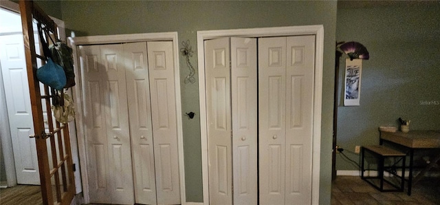 bedroom featuring two closets and baseboards