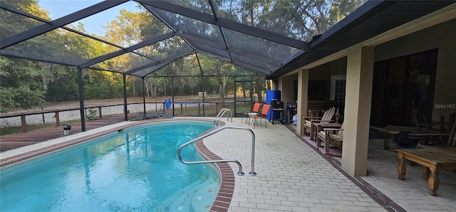 outdoor pool featuring a patio and glass enclosure