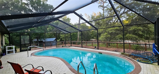 pool featuring a patio, a wooden deck, and glass enclosure