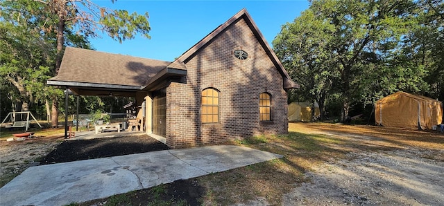 view of side of home featuring a ceiling fan, a patio area, and brick siding