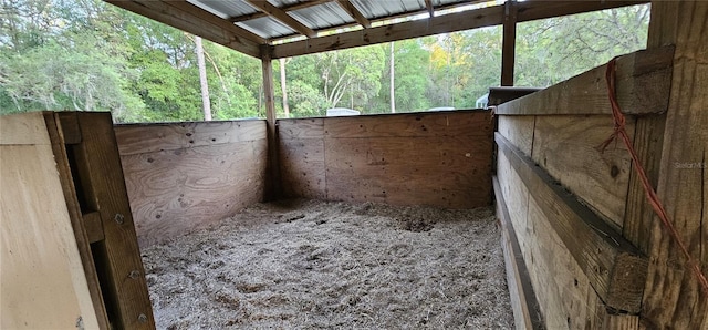 view of horse barn with a view of trees