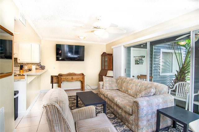 living area featuring light tile patterned floors, crown molding, a ceiling fan, and visible vents