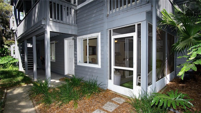 view of side of property featuring a balcony and a sunroom